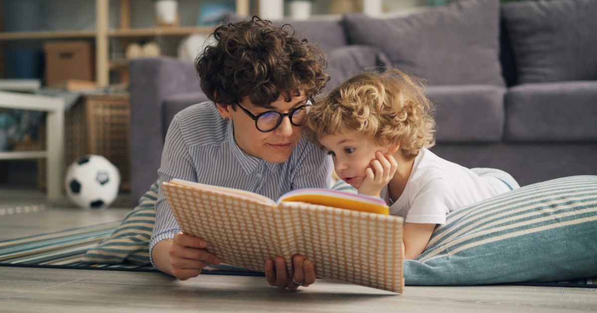 Eine Erwachsene Person und ein Kind lesen gemeinsam in einem Kinderbuch.